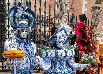 People in costume at the Venice Carnival in front of the Venetian Arsenal.