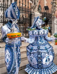 People in costume at the Venice Carnival in front of the Venetian Arsenal.