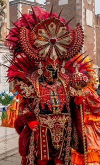 People in costume at the Venice Carnival in front of the Venetian Arsenal.