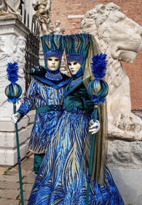 People in costume at the Venice Carnival in front of the Venetian Arsenal.