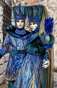 People in costume at the Venice Carnival in front of the Venetian Arsenal.