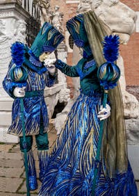 People in costume at the Venice Carnival in front of the Venetian Arsenal.