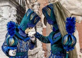 People in costume at the Venice Carnival in front of the Venetian Arsenal.