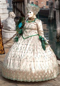 People in costume at the Venice Carnival in front of the Venetian Arsenal.