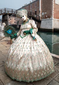 People in costume at the Venice Carnival in front of the Venetian Arsenal.