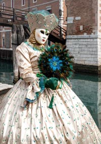 People in costume at the Venice Carnival in front of the Venetian Arsenal.