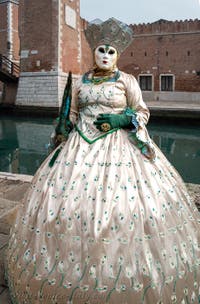 People in costume at the Venice Carnival in front of the Venetian Arsenal.