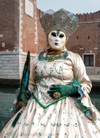 People in costume at the Venice Carnival in front of the Venetian Arsenal.