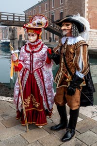 People in costume at the Venice Carnival in front of the Venetian Arsenal.