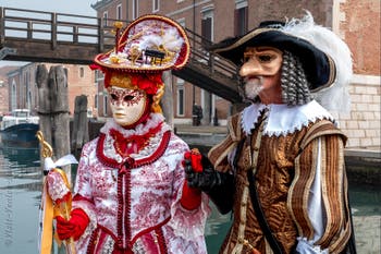 People in costume at the Venice Carnival in front of the Venetian Arsenal.