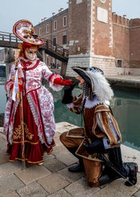 People in costume at the Venice Carnival in front of the Venetian Arsenal.