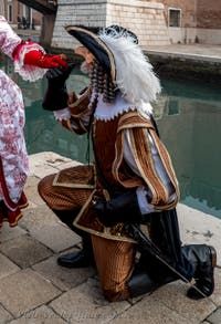 People in costume at the Venice Carnival in front of the Venetian Arsenal.