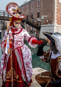 People in costume at the Venice Carnival in front of the Venetian Arsenal.