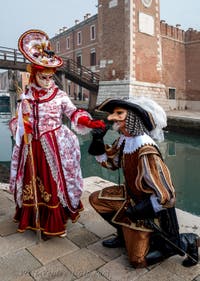 People in costume at the Venice Carnival in front of the Venetian Arsenal.