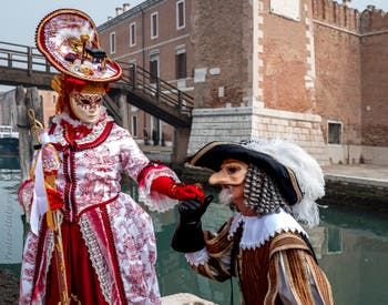 People in costume at the Venice Carnival in front of the Venetian Arsenal.