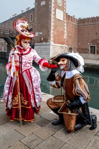 People in costume at the Venice Carnival in front of the Venetian Arsenal.