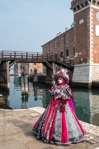 People in costume at the Venice Carnival in front of the Venetian Arsenal.