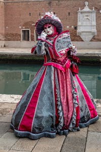 People in costume at the Venice Carnival in front of the Venetian Arsenal.