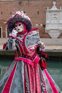 People in costume at the Venice Carnival in front of the Venetian Arsenal.