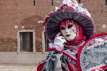 People in costume at the Venice Carnival in front of the Venetian Arsenal.