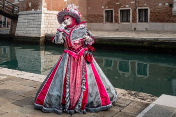 People in costume at the Venice Carnival in front of the Venetian Arsenal.