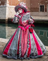 People in costume at the Venice Carnival in front of the Venetian Arsenal.