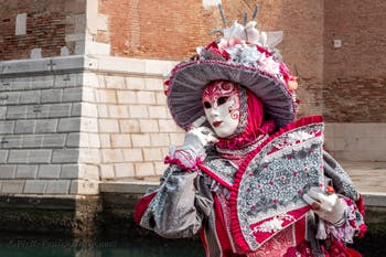 People in costume at the Venice Carnival in front of the Venetian Arsenal.