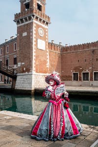 People in costume at the Venice Carnival in front of the Venetian Arsenal.