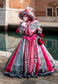 People in costume at the Venice Carnival in front of the Venetian Arsenal.