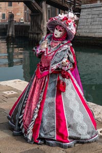 People in costume at the Venice Carnival in front of the Venetian Arsenal.