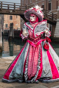 People in costume at the Venice Carnival in front of the Venetian Arsenal.