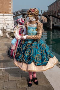 People in costume at the Venice Carnival in front of the Venetian Arsenal.