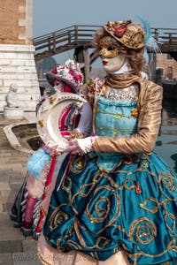 People in costume at the Venice Carnival in front of the Venetian Arsenal.