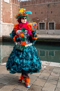 People in costume at the Venice Carnival in front of the Venetian Arsenal.