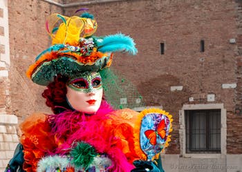 People in costume at the Venice Carnival in front of the Venetian Arsenal.