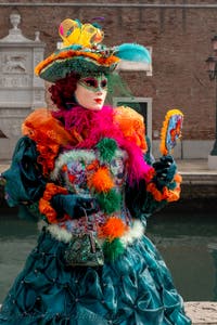 People in costume at the Venice Carnival in front of the Venetian Arsenal.