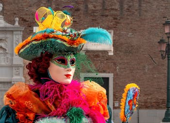 People in costume at the Venice Carnival in front of the Venetian Arsenal.