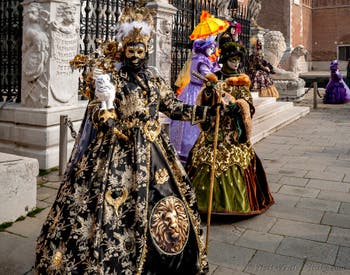 People in costume at the Venice Carnival in front of the Venetian Arsenal.