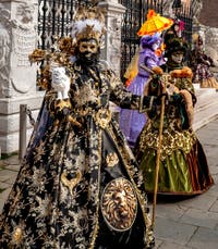 People in costume at the Venice Carnival in front of the Venetian Arsenal.