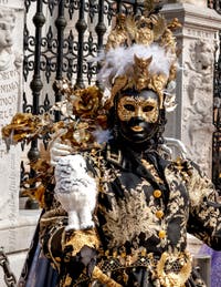 People in costume at the Venice Carnival in front of the Venetian Arsenal.