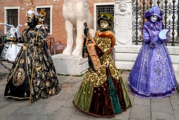 People in costume at the Venice Carnival in front of the Venetian Arsenal.