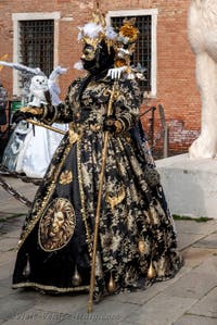 People in costume at the Venice Carnival in front of the Venetian Arsenal.