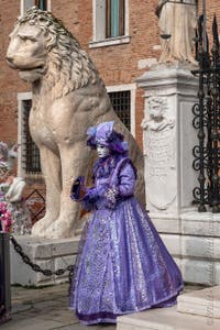 People in costume at the Venice Carnival in front of the Venetian Arsenal.