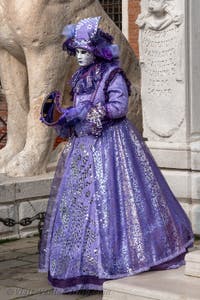 People in costume at the Venice Carnival in front of the Venetian Arsenal.