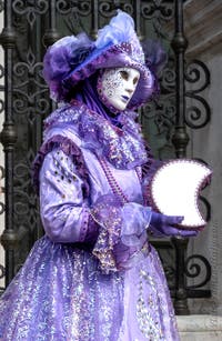 People in costume at the Venice Carnival in front of the Venetian Arsenal.