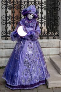 People in costume at the Venice Carnival in front of the Venetian Arsenal.