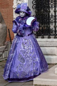 People in costume at the Venice Carnival in front of the Venetian Arsenal.