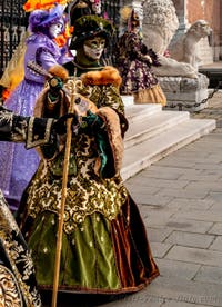 People in costume at the Venice Carnival in front of the Venetian Arsenal.