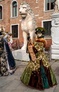 People in costume at the Venice Carnival in front of the Venetian Arsenal.