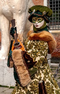 People in costume at the Venice Carnival in front of the Venetian Arsenal.